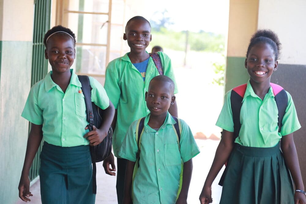 Excited children in senior primary school arrive at their new school, which once stood beneath a tree. The school received its first Form One high school students in February 2025.
